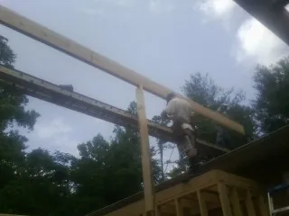 Carpenter setting a ridge beam over a new addition frame — Ice Dam Removal by Roofing Brothers in Rockaway Park