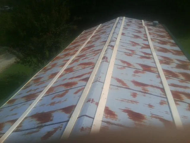 Rusted metal roof panels with new wood purlins before replacement — Storm Damage Roof Repair in Rockaway Park by Roofing Brothers