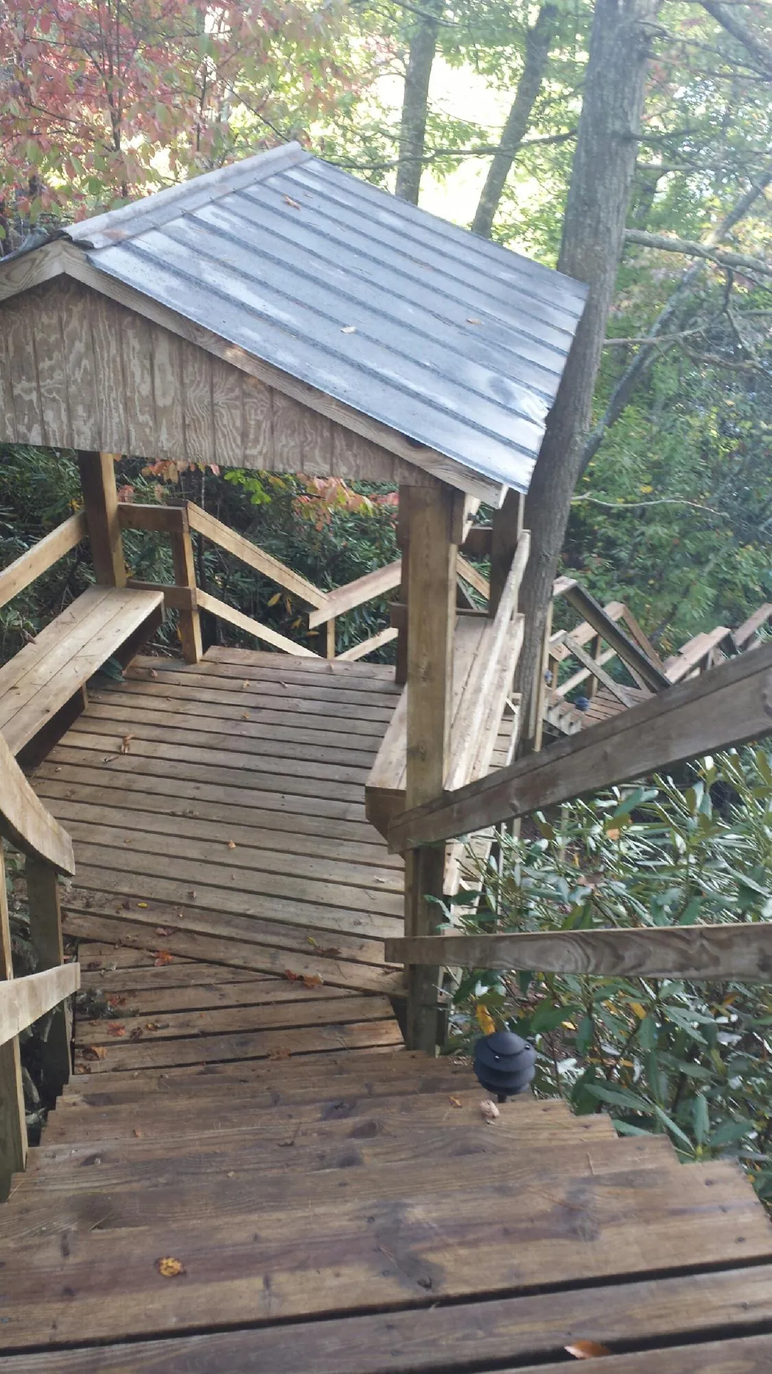 Metal roofed shelter over wooden steps on a wooded walkway — Skylight Repair & Installation work by our crew in Rockaway Park