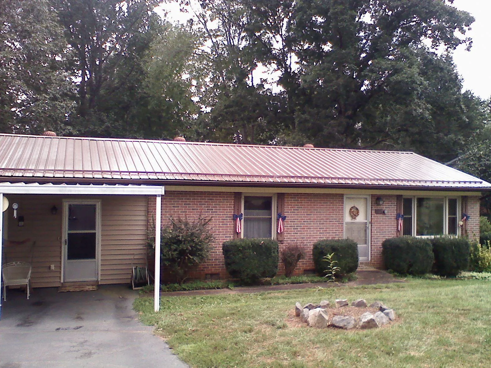 Bronze metal roof and carport on a brick ranch home — Roof Repair work by our crew in Rockaway Park